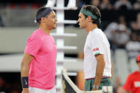 Trevor Noah and Roger Federer face off before the exhibition match held at the Cape Town Stadium in Cape Town, South Africa, Friday Feb. 7, 2020. (AP Photo/Halden Krog)
