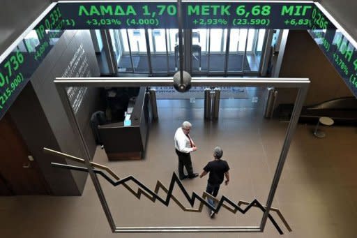 Employees walk at Athens stock exchange. World powers urged Greece to move quickly as coalition talks inched towards a possible national unity cabinet after an election win by pro-bailout parties that eased fears of a Greek eurozone exit