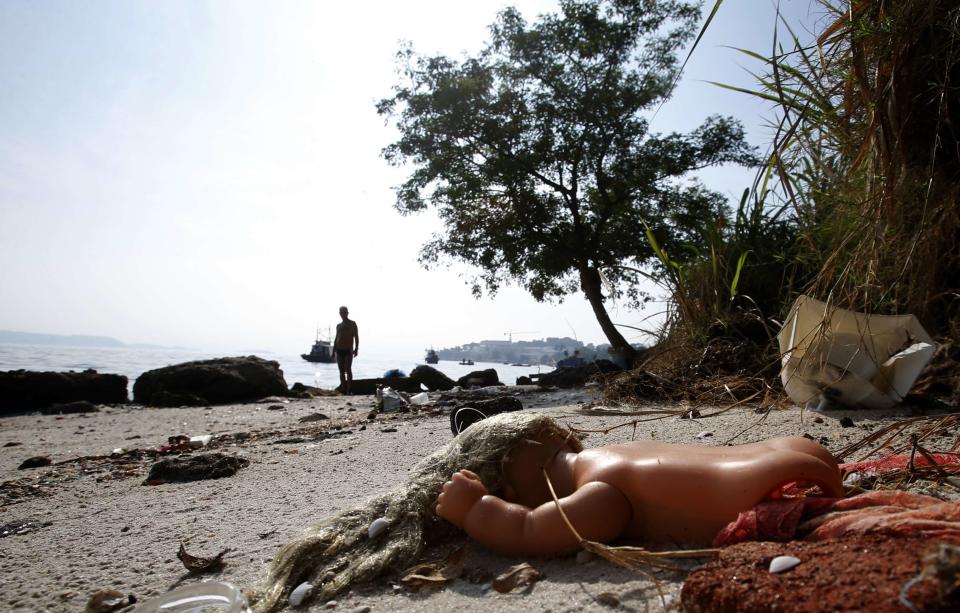 A toy doll is seen on Fundao beach in the Guanabara Bay in Rio de Janeiro March 13, 2014. According to the local media, the city of Rio de Janeiro continues to face criticism locally and abroad that the bodies of water it plans to use for competition in the 2016 Olympic Games are too polluted to host events. Untreated sewage and trash frequently find their way into the Atlantic waters of Copacabana Beach and Guanabara Bay - both future sites to events such as marathon swimming, sailing and triathlon events. REUTERS/Sergio Moraes (BRAZIL - Tags: ENVIRONMENT SPORT OLYMPICS)