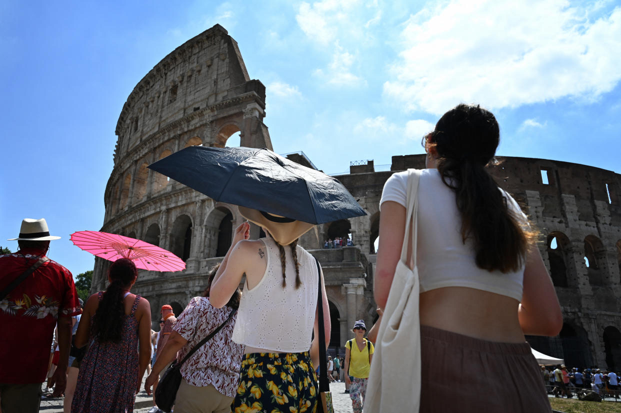 Tourists shelter from the sun with umbrellas near the Colosseum in Rome, on July 14, 2023, as Italy is hit by a heatwave. (Photo by Alberto PIZZOLI / AFP) (Photo by ALBERTO PIZZOLI/AFP via Getty Images)