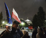 FILE - In this Jan. 23, 2020, file photo, a man holding a Poland and European Union flags take part in a protest outside Poland's parliament building in Warsaw, Poland. The European Union still hasn't completely sorted out its messy post-divorce relationship with Britain — but it has already been plunged into another major crisis. This time the 27-member union is being tested as Poland and Hungary block passage of its budget for the next seven years and an ambitious package aimed at rescuing economies ravaged by the coronavirus pandemic. (AP Photo/Czarek Sokolowski, File)