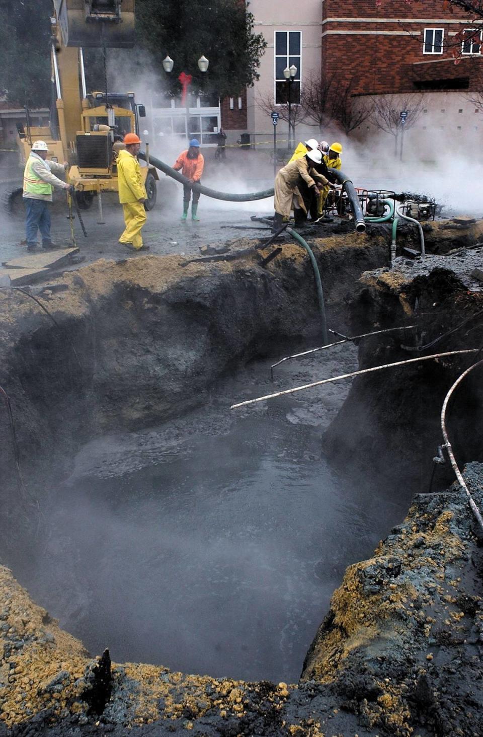 Work continues in the Paso Robles City Hall parking lot the day after the earthquake as they try to plug a 110-degree hot spring that shifted its cap and came back to life. The San Simeon Earthquake broke the decades old plug that held back the sulphur water.