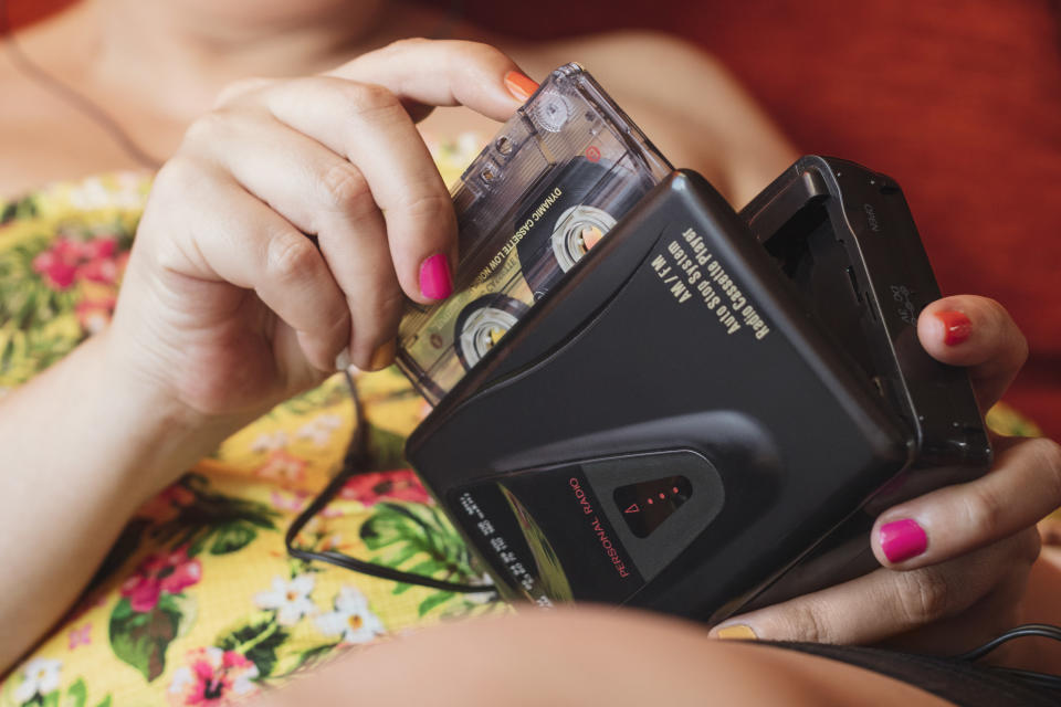 hand inserts a cassette tape into a player