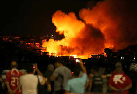 Residents look at houses on fire at Educando neighbourhood, a branch of the Rio Negro, a tributary to the Amazon river, in the city of Manaus, Brazil December 17, 2018. REUTERS/Bruno Kelly