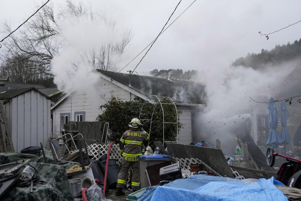 Firefighters battle a residence fire in Rio Dell, Calif., Wednesday, Dec. 21, 2022. (AP Photo/Godofredo A. Vásquez)