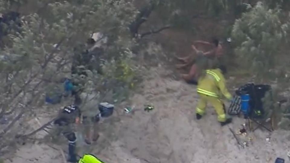 Emergency services and friends raced to rescue a 25-year-old man after he fell into a hole on Bribie Island and was buried in sand on December 2, 2023. Picture: Nine News