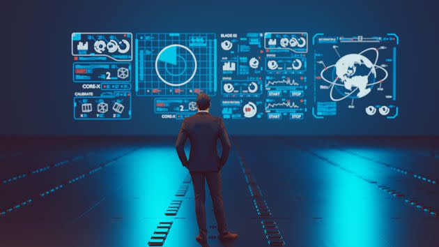 Man stands in front of a big hologram screen which has different symbols. He is analyzing data. Concept of data analysis and data complexity. (Photo: mikkelwilliam via Getty Images)