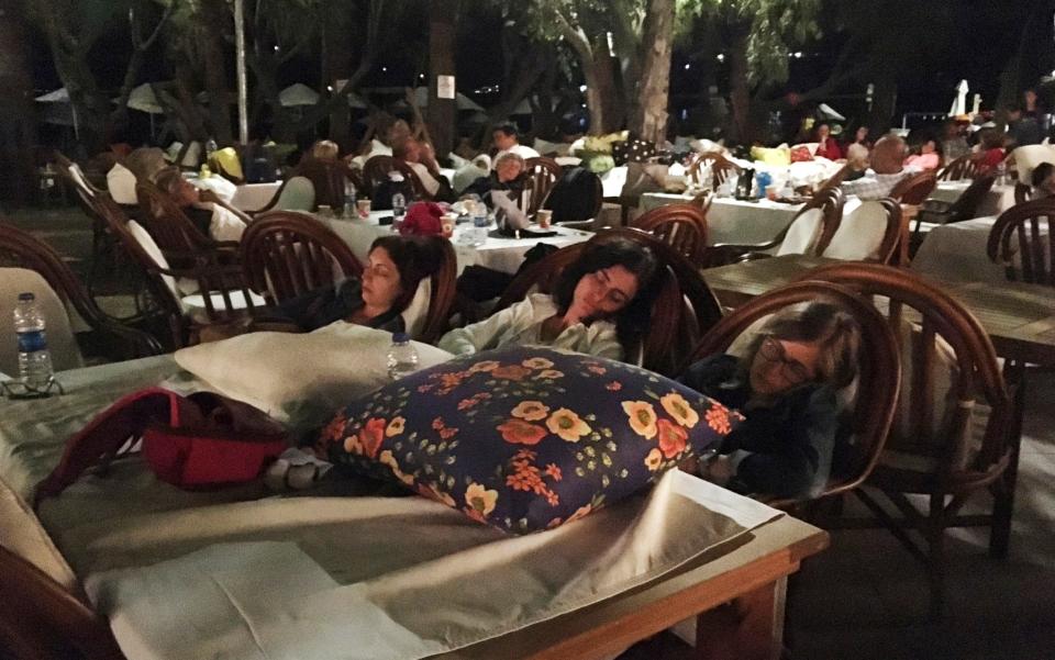 Hotel guests sleep outdoors after abandoning their rooms following an earthquake in Bitez, a resort town about 6 kilometers (4 miles) west of Bodrum - Credit: Ayse Wieting/AP