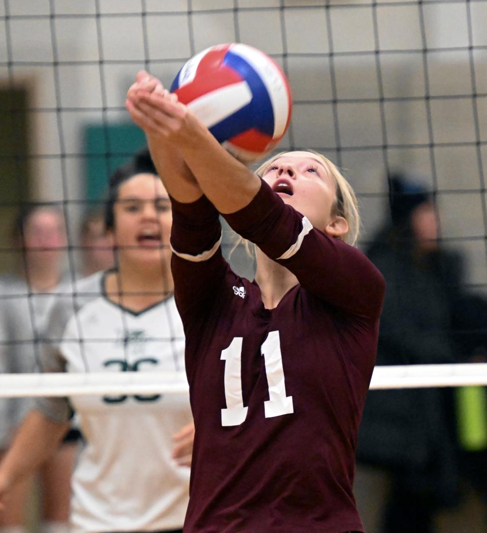 Mia Cooper of Falmouth hits the ball over her shoulder in Monday's game with Dennis-Yarmouth in South Yarmouth.