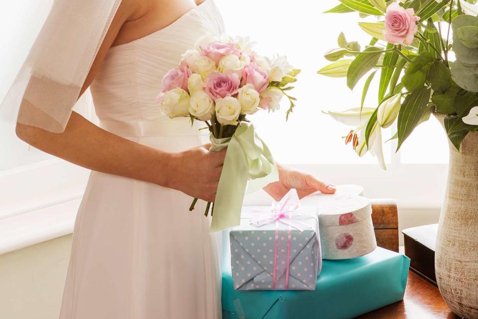<p>Betsie Van Der Meer/Getty</p> Stock photo of a bride with wedding gifts