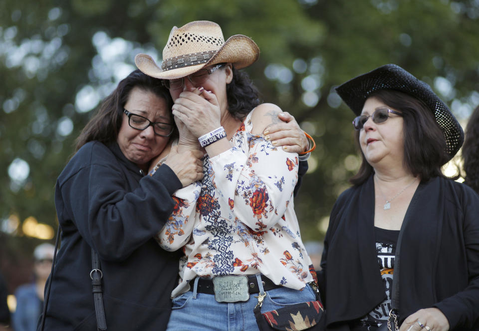 Yvonne Justice, left, comforts Emily Sebring during a ceremony Tuesday, Oct. 1, 2019, on the anniversary of the mass shooting two years earlier, in Las Vegas. (AP Photo/John Locher)