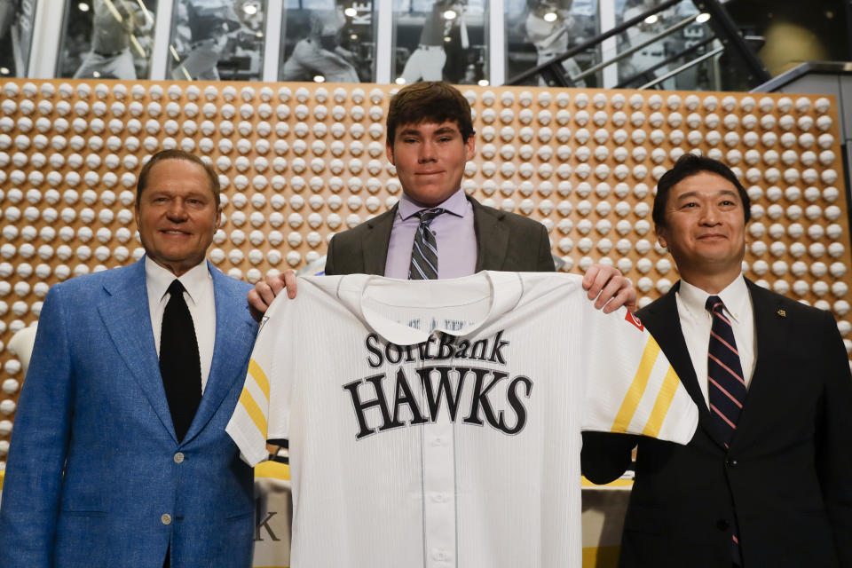 Sports agent Scott Boras, left, SoftBank Hawks pitcher Carter Stewart Jr., center, and Hawks General Manager, Sugihiko Mikasa pose during a baseball news conference in Newport Beach, Calif., Thursday, May 30, 2019. After failing to sign with Atlanta and losing a grievance against the Braves, 19-year-old right-hander Carter Stewart has agreed to a six-year contract with the Fukuoka SoftBank Hawks of Japan&#39;s Pacific League (AP Photo/Chris Carlson)