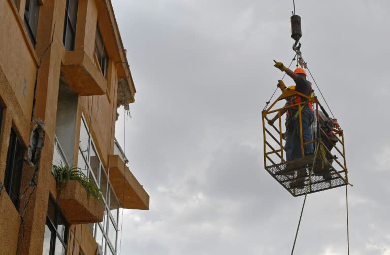 Technicians help residents recover some of their belongings from a building