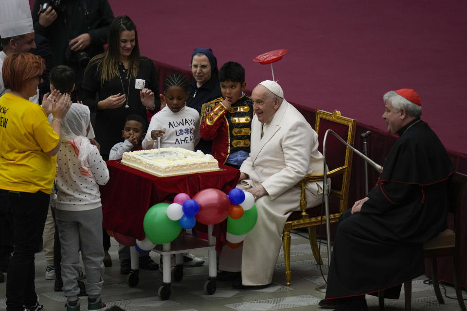 Pope Francis is offered a cake as he celebrates his birthday with children assisted by the Santa Marta dispensary during an audience in the Paul VI Hall, at the Vatican, Sunday, Dec. 17, 2023. Pope Francis turnes 87 on Dec.17. (AP Photo/Alessandra Tarantino)