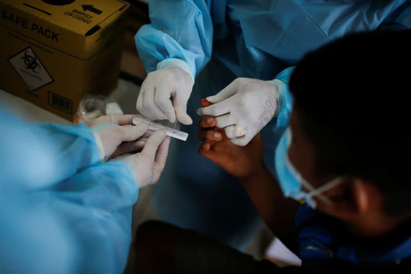 A member of Brazilian Armed Forces medical team examines a boy from the indigenous Yanomami ethnic group at the Surucucu region in the municipality of Alto Alegre, state of Roraima