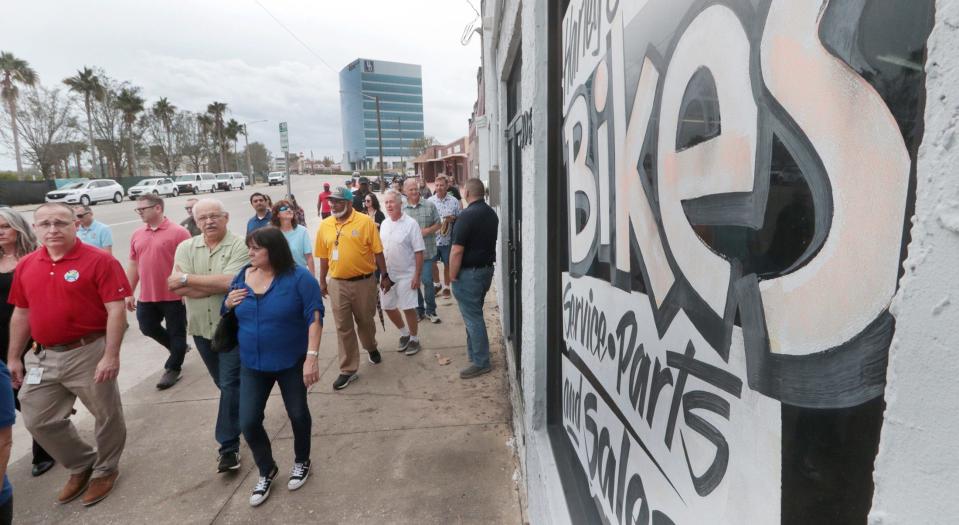 Daytona Beach City Manager Deric Feacher, pictured in the bright yellow shirt, and city staff members led a walking tour with business owners and residents on Beach Street in November as part of an effort to explore what needs redevelopment.