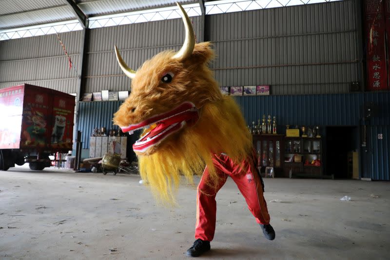 A member of Kun Seng Keng Lion and Dragon Dance Association, demonstrates a dance with an ox mask designed for Lunar New Year at a training centre, during an interview with Reuters, in Muar
