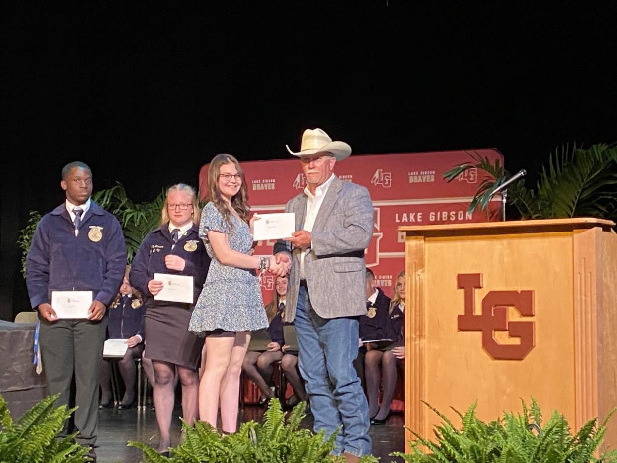 Michael Shaw, Kaley Baxter, and Hannah Lovering, left to right, were awarded scholarships by the Lake Gibson Future Farmers of America Alumni Association. Kenny Raney Jr. made the presentations.