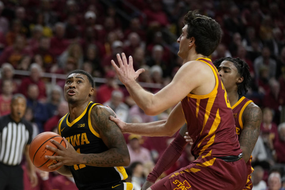 Iowa guard Tony Perkins (11) drives to the basket in front of Iowa State forward Milan Momcilovic, right, during the first half of an NCAA college basketball game, Thursday, Dec. 7, 2023, in Ames, Iowa. (AP Photo/Charlie Neibergall)