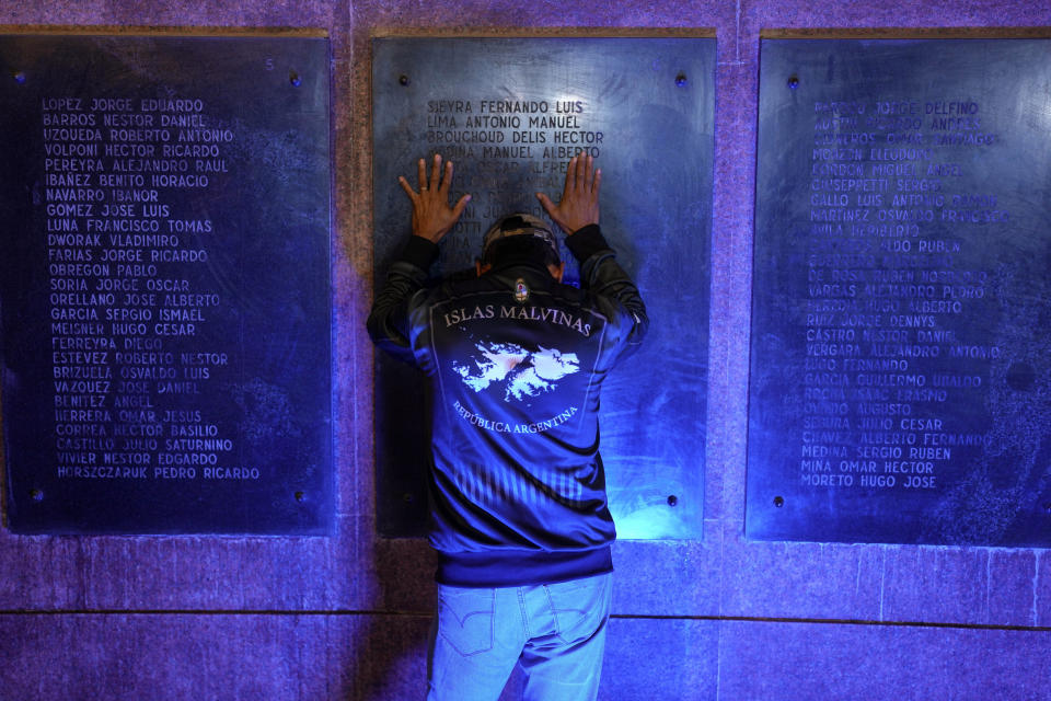 Un hombre, con la cabeza gacha, coloca sus manos sobre un monumento de guerra durante una ceremonia que conmemora el 42do aniversario del conflicto entre Argentina y Reino Unido por las Islas Malvinas, o Falkland, en Buenos Aires, Argentina, el 1 de abril de 2024. (AP Foto/Natacha Pisarenko)