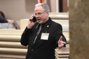 A man in a black suit on the phone