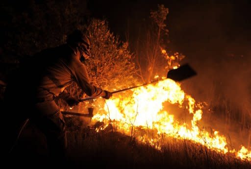 A firefigher tries to extinguish a wildfire in Ller near La Junquera (Girona), close to the Spanish-French border. The wildfire whipped up by strong winds left three people dead Sunday and about 100 people injured and forced thousands of residents to remain indoors, officials said