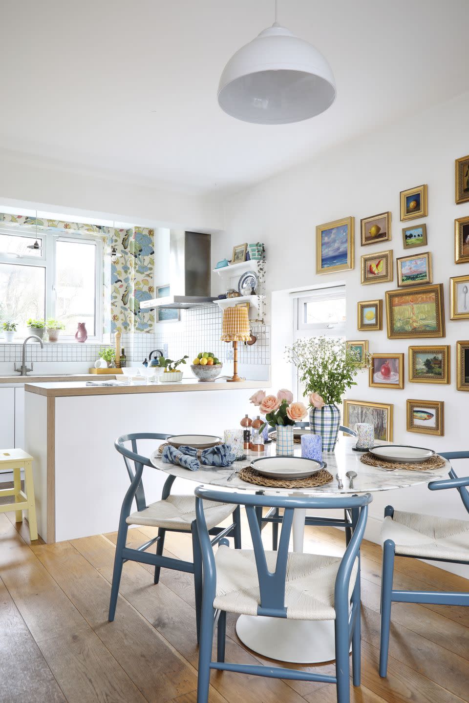 round white table in dining area of open plan kitchen with a gallery wall