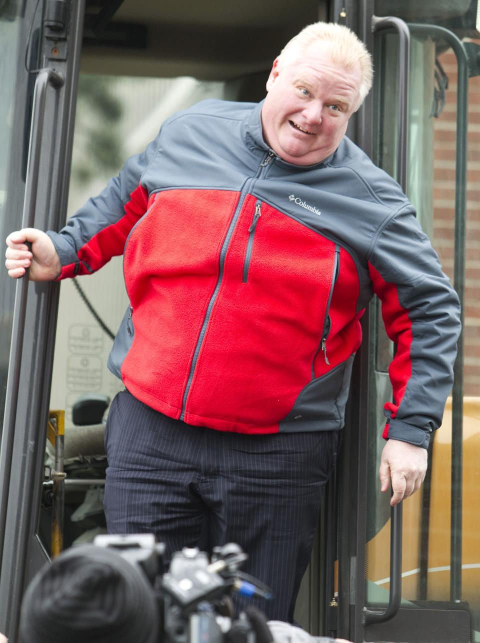 Toronto Mayor Rob Ford climbs into a snow plow cab at a news conference at a public works yard to discussing the city's winter snow plowing agenda