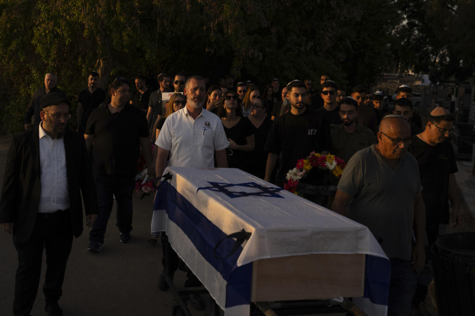 Mourners carry a coffin draped with the Israeli flag during the funeral of the Israeli man Sagiv Ben Svi, killed by Hamas militants while attending a music festival, at a cemetery in Holon, central Israel, Thursday, Oct. 26, 2023. More than 1,400 people were killed and over 200 taken captive in an multi-front attack by the militant group that rules Gaza on Oct. 7.(AP Photo/Petros Giannakouris)