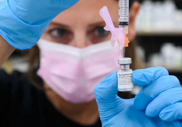 A pharmacist draws up a dose of the Pfizer-BioNTech COVID-19 vaccine in Toronto on Friday. There have been growing reports of Canadians turning down second doses of Moderna at vaccine clinics if they'd already received a shot of Pfizer, over misguided concerns that mixing the two shots may not be as safe or effective. (Nathan Denette/The Canadian Press - image credit)