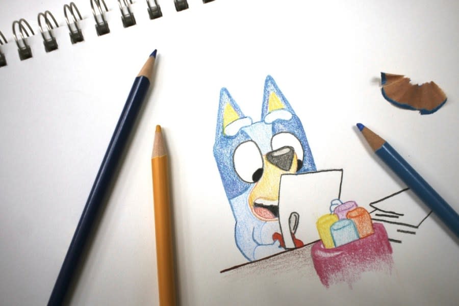 Colored pencils sit around a drawing of “Bluey” the Australian kids’ television program character on a sketch pad Friday, April 19, 2024, in Phoenix, Ariz. (AP Photo/Cheyanne Mumphrey)