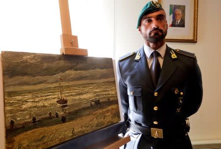 An Italian policeman stands next to a painting by the Dutch artist Vincent Van Gogh, that was stolen in Amsterdam 14 years ago, during a news conference in Naples September 30, 2016. REUTERS/Ciro De Luca