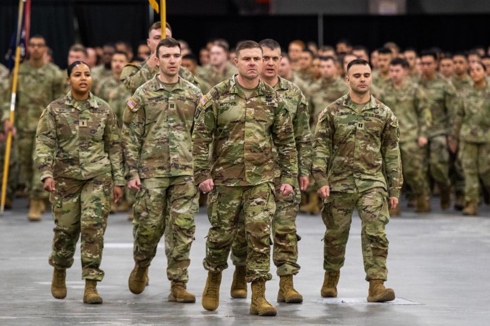 Maj. Douglas K. Patterson of Hudson, center, leads the 181st Infantry Regiment into the DCU Center Tuesday.