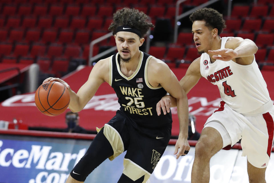 Wake Forest's Ismael Massoud (25) drives by North Carolina State's Jericole Hellems (4) during the first half of an NCAA college basketball game Wednesday, Jan. 27, 2021, in Raleigh, N.C. (Ethan Hyman/The News & Observer via AP, Pool)