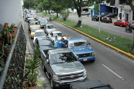 People with their vehicles wait in line to refuel at a gas station of the state oil company PDVSA in San Cristobal, Venezuela, May 17, 2019. REUTERS/Carlos Eduardo Ramirez