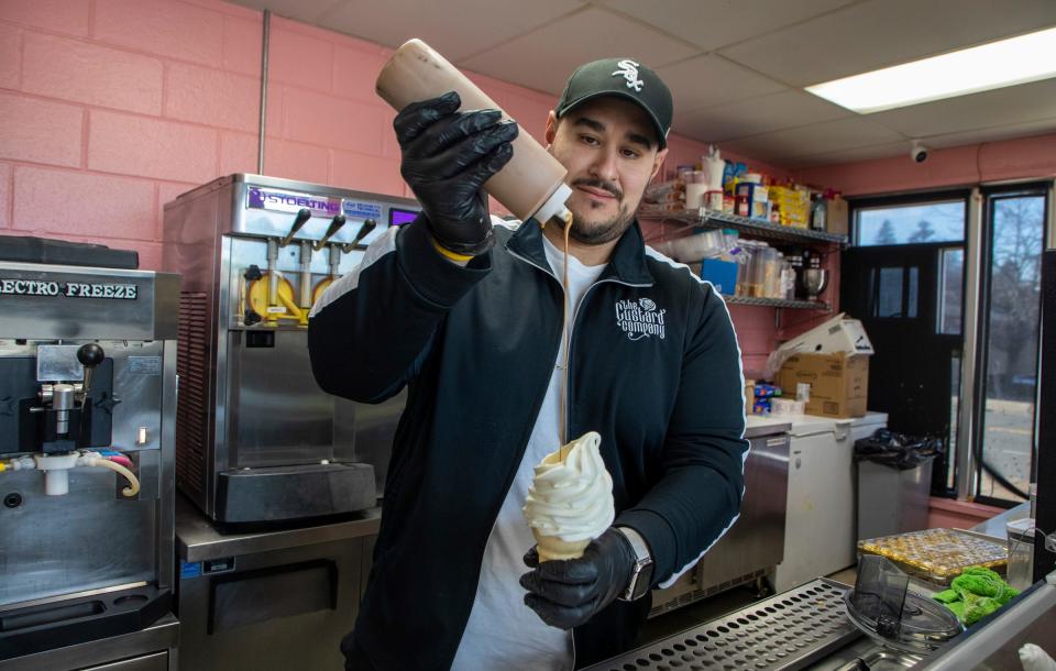 Owner of The Custard Company, Jamal Jawad, puts syrup on an frozen custard cone inside his business in Dearborn on Wednesday, March. 8, 2023.