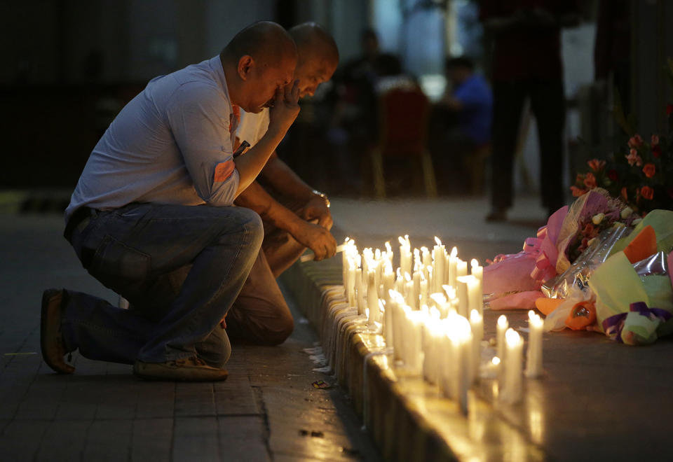 <p>A man holds back tears as he lights candles for victims in an attack at the Resorts World Manila complex, Friday, June 2, 2017, in Manila, Philippines. (Photo: Aaron Favila/AP) </p>