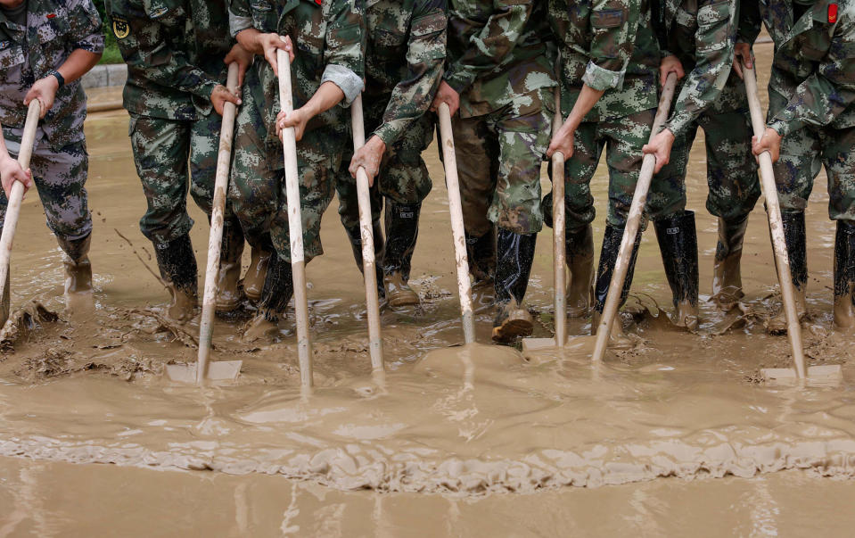 Policemen sweep a flooded street