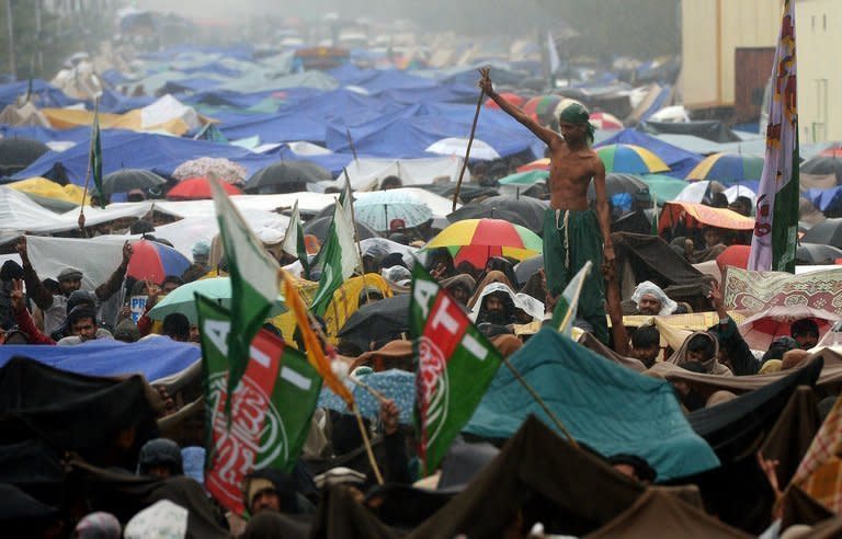 Supporters of Pakistani cleric Tahir-ul Qadri gather in the rain at a protest rally in Islamabad on January 17, 2013. Qadri called off a mass protest in Islamabad, averting a major political crisis and reaching a deal with the government that paves the way for elections within months