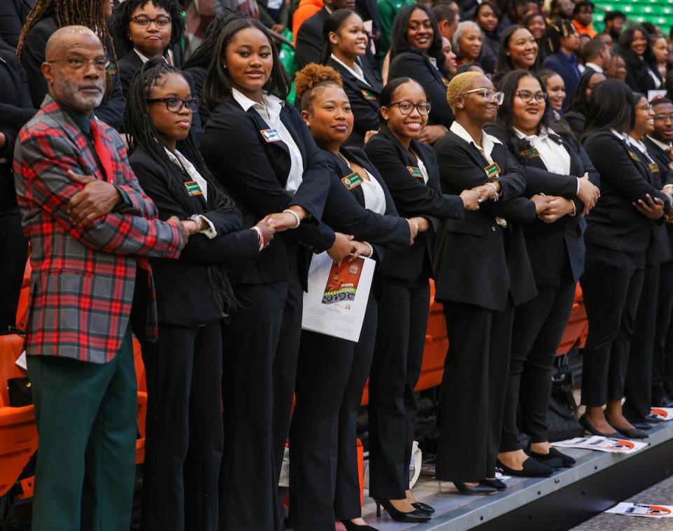 Students hold hands and sway side to side as the FAMU Wind Symphony performs the civil rights anthem "We Shall Overcome" during the university's MLK Convocation on Friday, January 12, 2024.