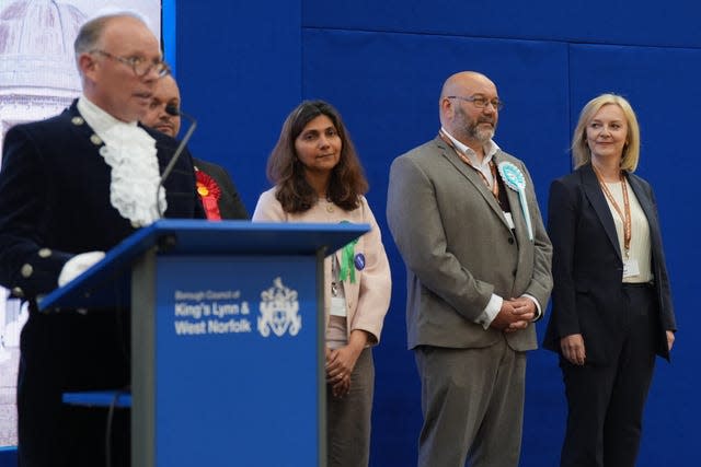 A dignitary stands to make the declaration of the poll for South West Norfolk with a series of candidates - Liz Truss is to the very right of the picture