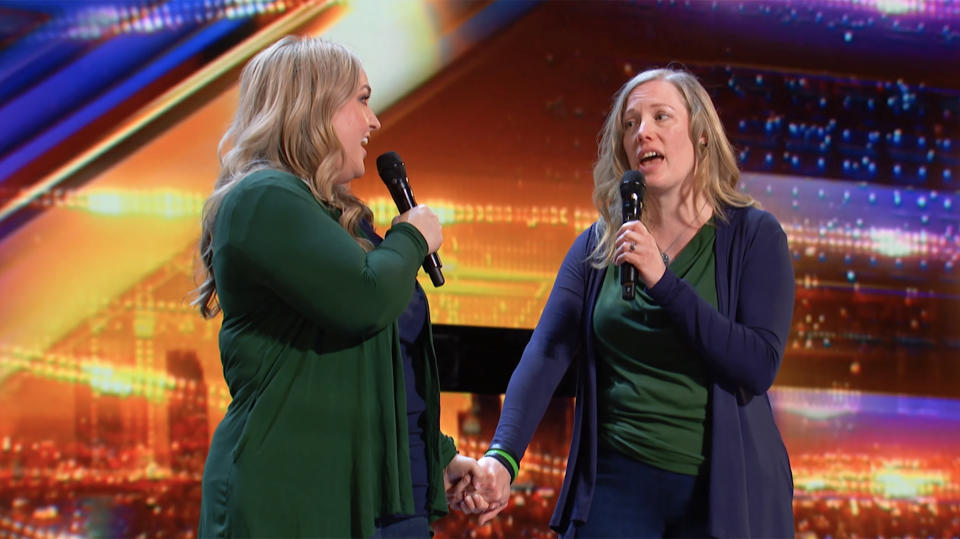 Moms Holly and Kim hold hands while singing 