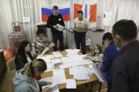 Members of an election commission count ballots after voting at a polling station after the Parliamentary elections in Nikolayevka village outside Omsk, Russia, Sunday, Sept. 19, 2021. From the Baltic Sea to the Pacific Ocean, Russians across eleven time zones voted Sunday on the third and final day of a national election for a new parliament, a ballot in which the pro-Kremlin ruling party is largely expected to retain its majority after months of relentless crackdown on the opposition. (AP Photo/Evgeniy Sofiychuk)