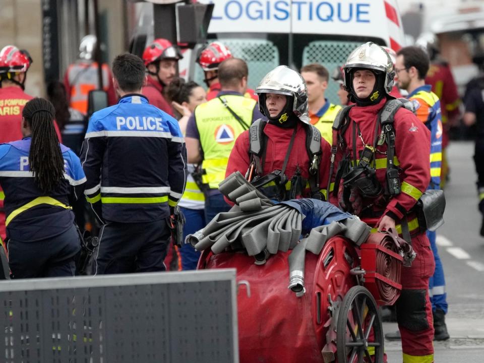 Police officers and rescue workers work at the scene (AP)