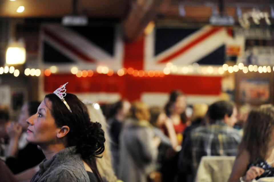 FILE - Valerie Malas watches the royal wedding of Britain's Prince William and Kate Middleton live on television at the Globe Pub in Chicago, April 29, 2011. The pomp, the glamour, the conflicts, the characters — when it comes to the United Kingdom’s royal family, the Americans can’t seem to get enough. (AP Photo/Paul Beaty, File)