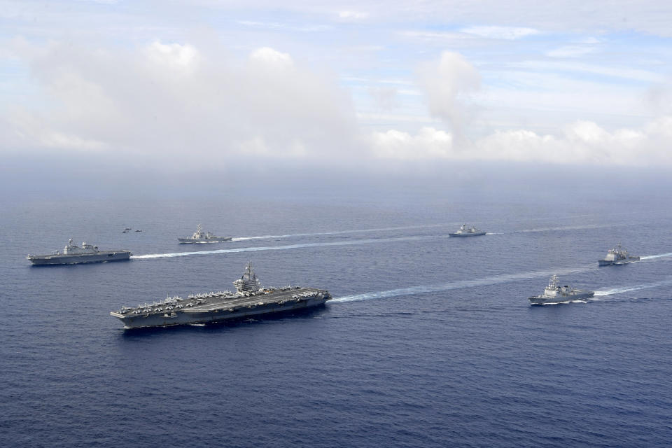 In this photo provided by South Korea's Defense Ministry, U.S. nuclear-powered aircraft carrier USS Ronald Reagan, second from left, and South Korea's landing platform helicopter (LPH) ship Marado, left, sail during a joint military exercise at an undisclosed location, Saturday, June 4, 2022. (South Korea Defense Ministry via AP)