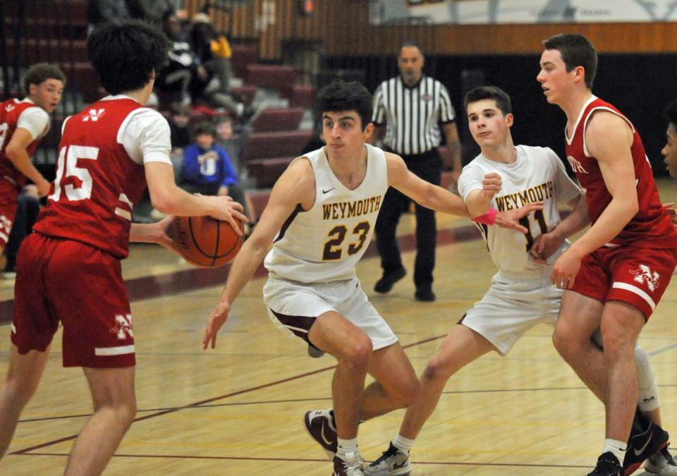 North Attleborough's Jonnie Obuchowski left, runs into Weymouth defenders Dylan Umano, center, and Connor Lovely, second from right, during boys basketball action at Weymouth High School, Monday, Monday, Feb. 20, 2023.