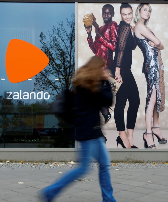 FILE PHOTO: A woman walks past the logo of fashion retailer Zalando in Berlin