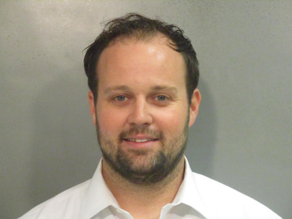 josh duggar in a white button down shirt smiles in a mug shot (Washington County Sheriff's Office)