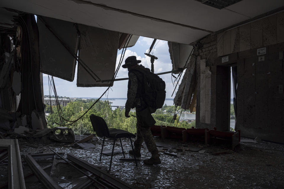 A Ukrainian serviceman walks inside of the headquarters of the Mykolaiv Regional Military Administration building destroyed by a Russian attack in Mykolaiv, Ukraine, Friday, Aug. 5, 2022. (AP Photo/Evgeniy Maloletka)